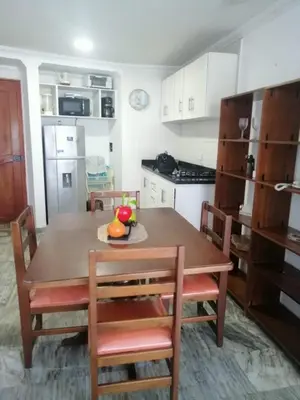 a kitchen with a wooden table and chairs and a kitchen with white cabinets at Cartagena de Indias, Mar, historia y diversión ! in Cartagena de Indias