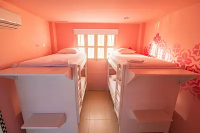 two bunk beds in a room with orange walls at San Felicin Hostel in Cartagena de Indias