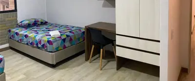 a small bedroom with a bed and a desk at LivinnX Barranquilla in Barranquilla