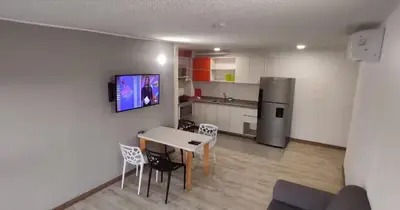 a kitchen with a table and chairs and a refrigerator at LivinnX Barranquilla in Barranquilla