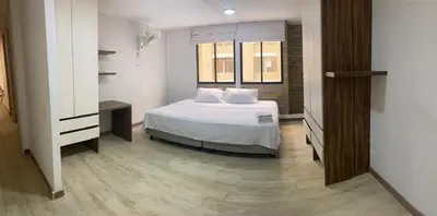 a bedroom with a bed with white sheets and a window at LivinnX Barranquilla in Barranquilla