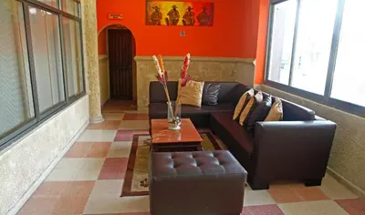 a living room with two leather couches and a table at Hotel Rivera Del Mar in Barranquilla