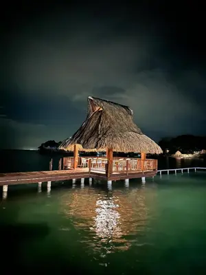 a hut on a dock in the water at night at Hotel Isla del Sol in Isla Grande