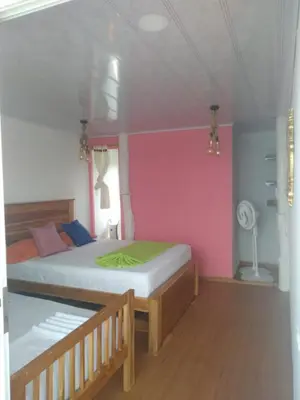 a bedroom with a bed and a pink wall at posada donde Uriel Playa tranquila in Baru