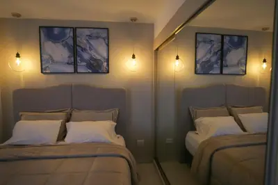 a bedroom with two beds and lights on the wall at Apartamento Edificio Portofino 701 in Cartagena de Indias