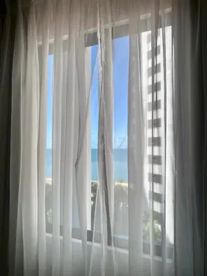 a window with white curtains with a view of the ocean at Apartamento Edificio Portofino 701 in Cartagena de Indias