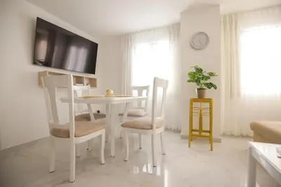 a white dining room with a table and chairs at Apartamento Edificio Portofino 701 in Cartagena de Indias