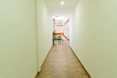 a hallway with white walls and a tile floor at Hospedaje Mi Fortaleza, Con Piscina, Parqueadero y estamos a 10 Minutos Caminando a Playa Dormida in Santa Marta