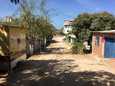 an empty street in a village with a building at Hospedaje Mi Fortaleza, Con Piscina, Parqueadero y estamos a 10 Minutos Caminando a Playa Dormida in Santa Marta