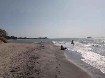 a group of people on a beach near the water at Hospedaje Mi Fortaleza, Con Piscina, Parqueadero y estamos a 10 Minutos Caminando a Playa Dormida in Santa Marta