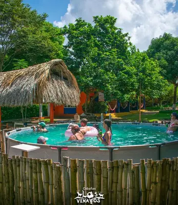 a group of people in a swimming pool at Cabañas Los Venaos in San Bernardo del Viento