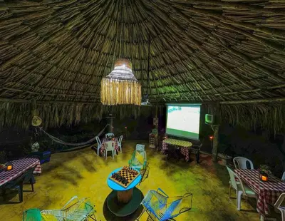 a room with a large screen in a thatch roof at Cabañas Los Venaos in San Bernardo del Viento