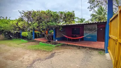a house with a hammock in front of it at Cabañas Los Venaos in San Bernardo del Viento