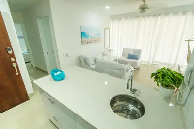 a kitchen with a sink and a living room at Hermoso apartamento en la playa in Cartagena de Indias