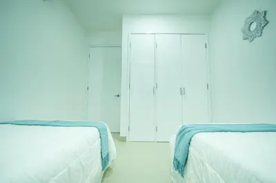 two beds in a room with white walls and blue ceilings at Hermoso apartamento en la playa in Cartagena de Indias