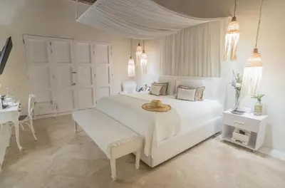 a white bedroom with a large white bed and a table at Casa Diluca Cartagena Hotel Boutique in Cartagena de Indias