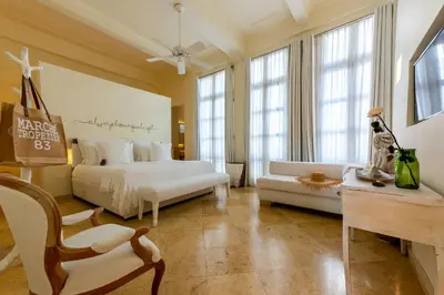 a bedroom with two beds and a couch and a chair at Casa Diluca Cartagena Hotel Boutique in Cartagena de Indias