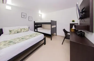 a bedroom with a bed and a tv and a desk at Hotel Marina Suites By GEH Suites in Cartagena de Indias