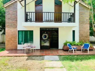 a house with a patio with chairs and a balcony at Santa Marta Bello Horizonte - Cabañas Don Rafa in Santa Marta