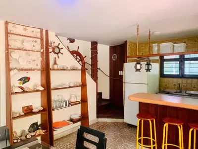 a kitchen with a counter and a white refrigerator at Santa Marta Bello Horizonte - Cabañas Don Rafa in Santa Marta