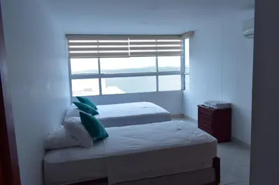a bedroom with two beds and a window at Apartamento en Cartagena Edificio El conquistador Sector el Laguito - By Corfeinco in Cartagena de Indias