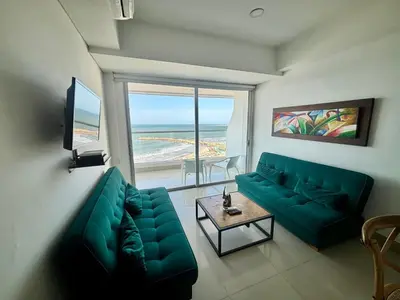 a living room with a green couch and a view of the ocean at Playa Cartagena Apartments in Cartagena de Indias
