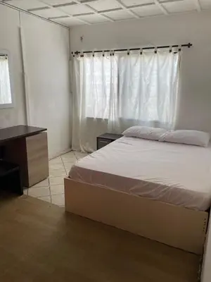 a bedroom with a bed and a desk and a window at La Quinta Bacana La Campiña in Barranquilla