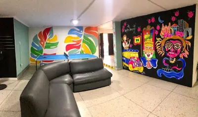 a living room with a couch and a colorful wall at La Quinta Bacana La Campiña in Barranquilla