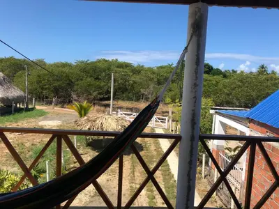 a hammock on the porch of a house at Cabaña La Blanquita in San Bernardo del Viento