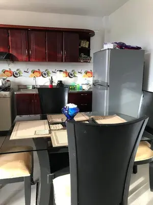 a kitchen with a table with chairs and a refrigerator at Cabaña La Blanquita in San Bernardo del Viento