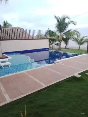 a swimming pool in a yard with palm trees at Casa de Playa frente al mar. in Coveñas