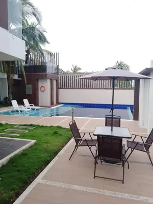a table and chairs with an umbrella next to a pool at Casa de Playa frente al mar. in Coveñas