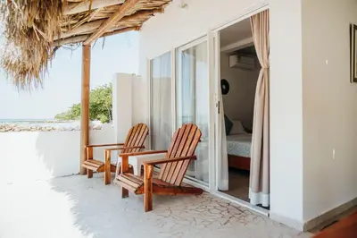 a room with two chairs and a table on a balcony at Hotel Carey Beach Baru in Baru