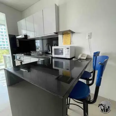 a kitchen with a counter with a microwave and blue chairs at Cartagena apartamento in Cartagena de Indias