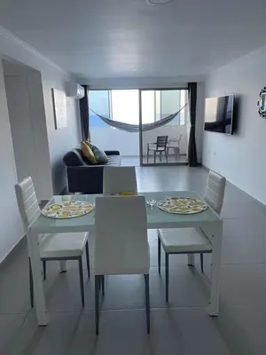 a dining table and chairs in a living room at Hermoso Apartamento, con vista al mar, en Cartagena de Indias, dos cuartos in Cartagena de Indias