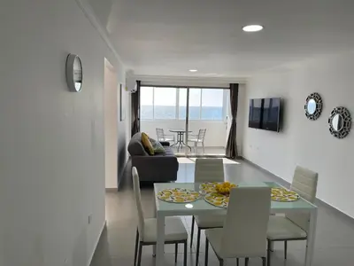 a dining room and living room with a table and chairs at Hermoso Apartamento, con vista al mar, en Cartagena de Indias, dos cuartos in Cartagena de Indias