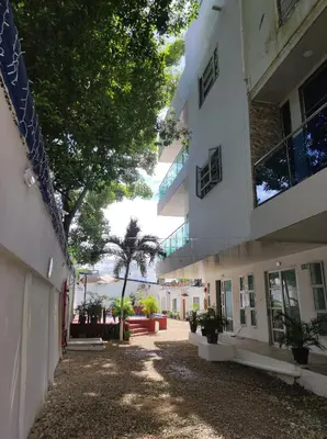 an empty courtyard of a building with a tree at Apartamentos Villa Leonor in Coveñas