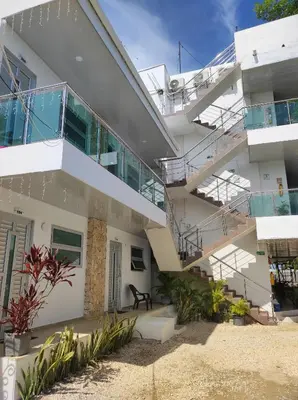 a white building with stairs and plants at Apartamentos Villa Leonor in Coveñas