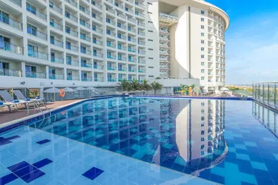 a swimming pool in front of a building at GHL Corales de Indias in Cartagena de Indias