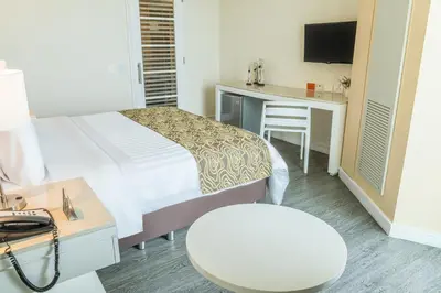 a hotel room with a bed and a desk and a chair at GHL Corales de Indias in Cartagena de Indias