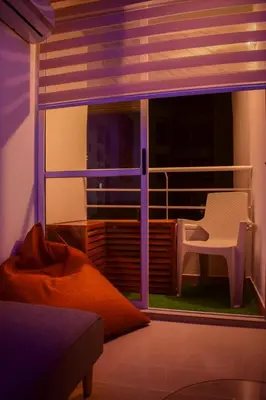a room with a window with a chair on a balcony at Luxury apartamento ubicación central y piscina. in Cartagena de Indias