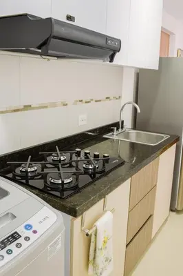 a kitchen with a stove and a sink at Luxury apartamento ubicación central y piscina. in Cartagena de Indias