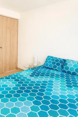 a bedroom with a bed with a blue bedspread at Luxury apartamento ubicación central y piscina. in Cartagena de Indias