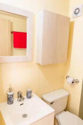 a bathroom with a white toilet and a mirror at Luxury apartamento ubicación central y piscina. in Cartagena de Indias