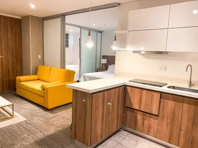 a kitchen with a yellow chair and a bedroom at Gz Tower Apartamento Barranquilla in Barranquilla