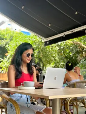 a woman sitting at a table with a laptop at Gz Tower Apartamento Barranquilla in Barranquilla