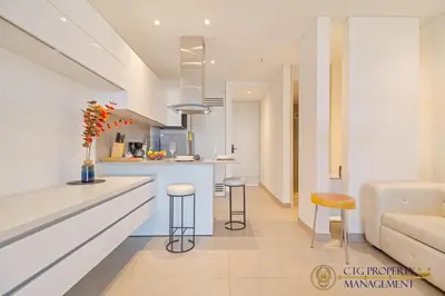 a kitchen and living room with a counter and stools at Distrito 90 - Estudios y Apartamentos para vacaciones y viajes de negocio in Barranquilla