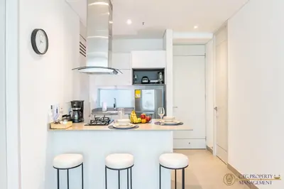 a kitchen with a counter and stools in a room at Distrito 90 - Estudios y Apartamentos para vacaciones y viajes de negocio in Barranquilla