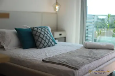 a bed with pillows on top of it in a room at Distrito 90 - Estudios y Apartamentos para vacaciones y viajes de negocio in Barranquilla
