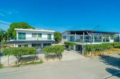 an aerial view of a white building with trees at Cabañas Melany in Coveñas